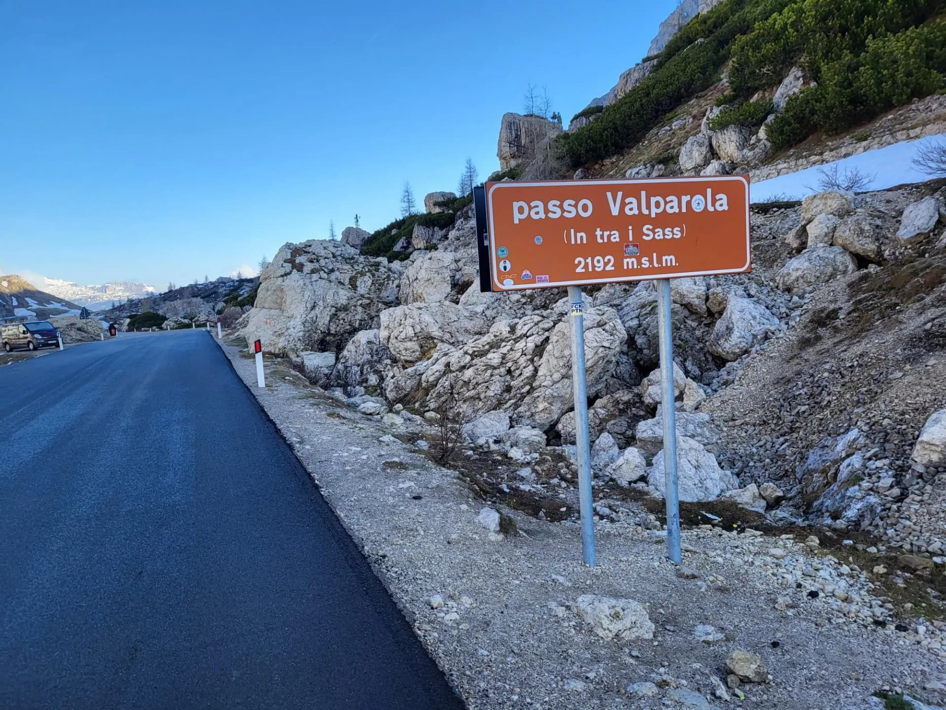 Passo Valparola sign at 2192 m.s.l.m. next to asphalt road in rocky mountain setting.